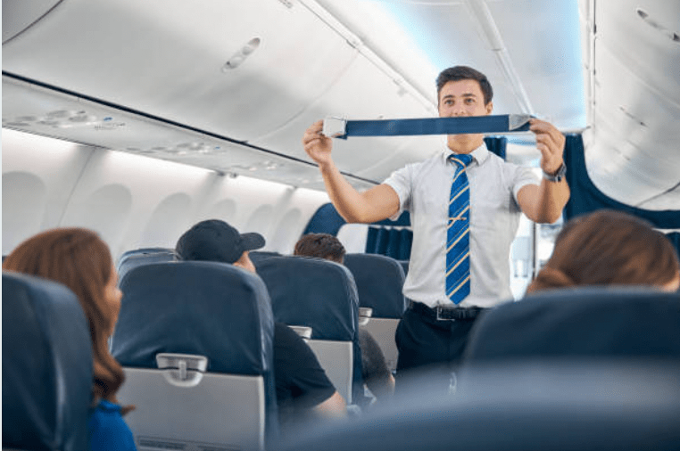 Flight attendant gives safety demonstration to passengers.