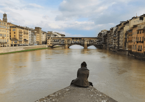 Traveler sits alone, taking in surrounding sights.